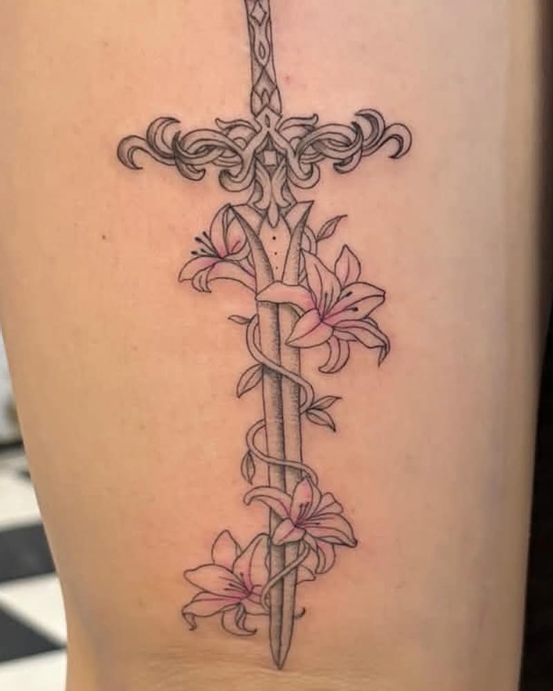 Épée ornée de fleurs de lys enroulées, fineline sur la cuisse